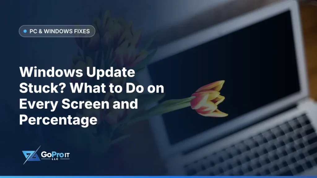Silver laptop with a dark blank screen beside a vase of tulips