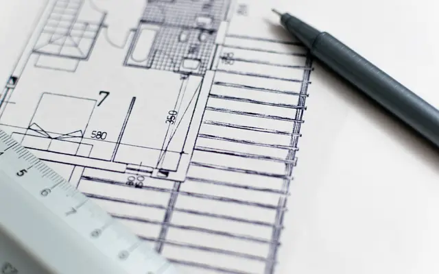 Architectural floor plan drawing with a black pen and scale ruler